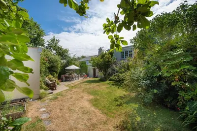 a garden with a pathway leading to a house at Pump Cottage in Gwithian