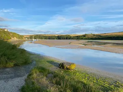 a body of water with a rock on the shore at 1 Chatsworth Riverscape Apartments - Riverview apartment in great location with free parking overlooking the Gannel just a short walk from Newquays incredible beaches and local amenities in Newquay