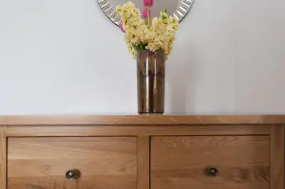 a vase of flowers sitting on top of a dresser at Hebaska in Carbis Bay