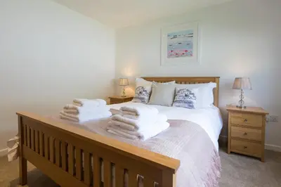 a bedroom with a bed with towels on it at Hebaska in Carbis Bay