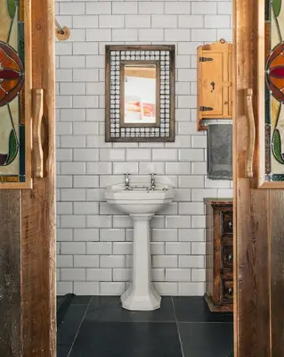 a white bathroom with a sink and a window at Sea View at Widemouth Bay - 3 bedroom cottage in Poundstock