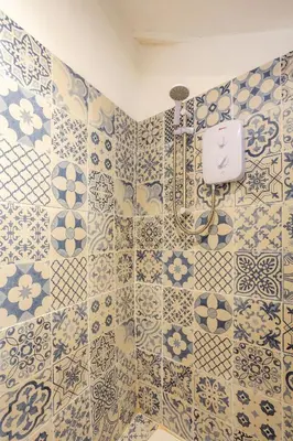 a bathroom with blue and white tiles on the wall at The Olde Piggery, on the coast, Zennor, St Ives in Zennor