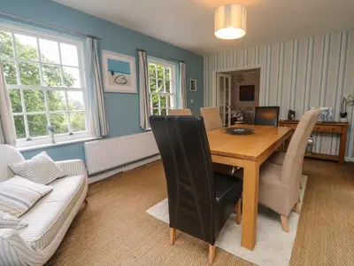 a living room with a table and a couch at Gweek House in Helston