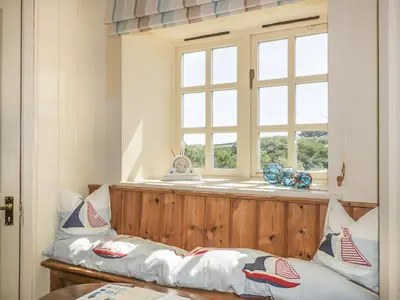 a room with a bench with pillows and a window at Foxes Den in Saint Goran