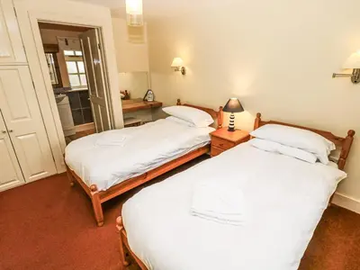 two twin beds in a room with a mirror at Foxes Den in Saint Goran