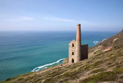an old building on a hill next to the ocean at Jade Cottage in St. Agnes