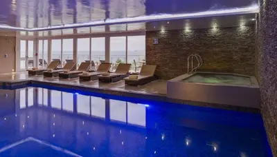 a pool with chairs and a tub in a building at Coast in St Ives