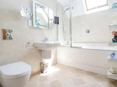 a bathroom with a toilet and a sink and a shower at Ocean Blue in Carbis Bay