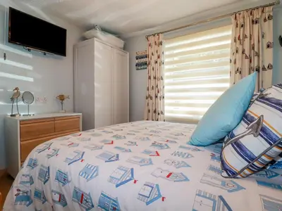 a bedroom with a large bed and a television at Woodside in Liskeard
