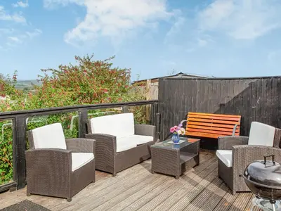 a deck with wicker chairs and a wooden bench at Tanglewood in Bugle