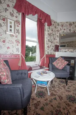 a living room with two chairs and a table at Penrose Bed & Breakfast in Lostwithiel