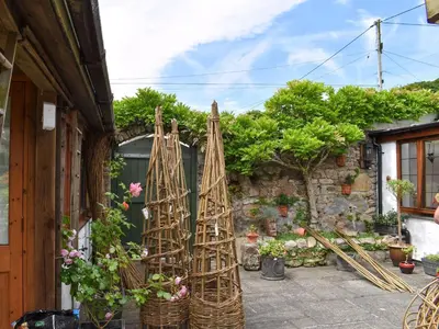 a garden with a bamboo structure on the side of a building at Tinners Gate in Saint Cleer