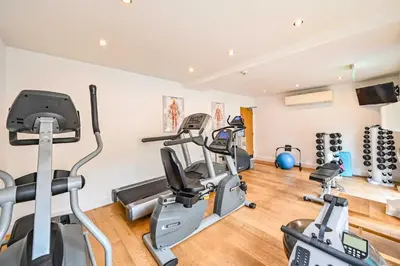 a gym with several treadmills and cardio machines at House 11 in Looe