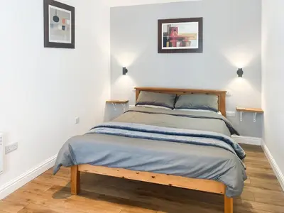 a bedroom with a bed with a wooden bed frame at Chi Lowen in Camborne