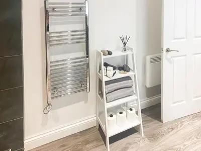 a bathroom with a white shelf with towels at Chi Lowen in Camborne