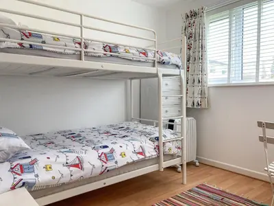 a bedroom with two bunk beds and a window at Zephyr's View in Poundstock