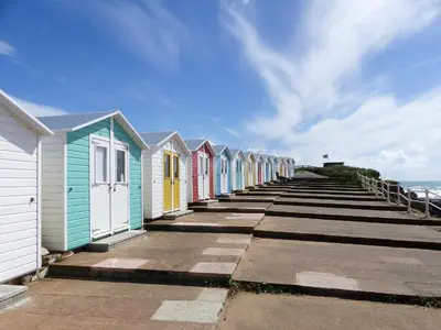 a row of colourful beach houses on a pier at Zephyr's View in Poundstock