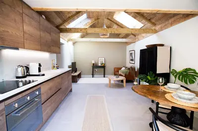 a kitchen with wooden cabinets and a wooden table at Mowhay Barn in Bodmin