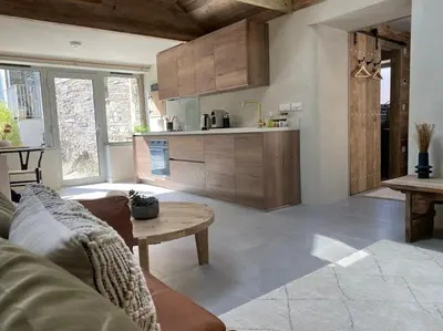a kitchen and living room with a couch and a table at Mowhay Barn in Bodmin