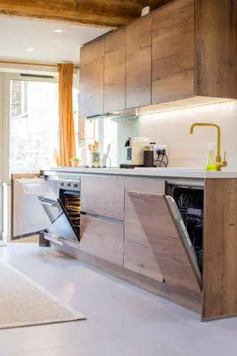 a kitchen with wooden cabinets and a sink at Mowhay Barn in Bodmin