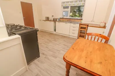 a kitchen with a wooden table and a stove at Yngywidden in Penzance