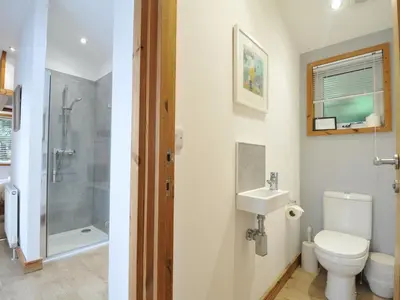 a bathroom with a toilet and a shower and a sink at 3 Southern Place in Liskeard