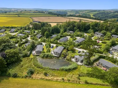 an aerial view of a house with a pond at 4 Faraway Fields in Liskeard