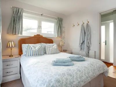 a bedroom with a bed with blue towels on it at Semybadazee in Poundstock