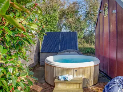 a hot tub in a garden with a chair at The Observatory-Uk41754 in Lanreath