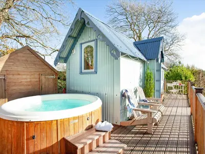 a hot tub on a deck next to a house at The Tabernacle-Uk41753 in Lanreath