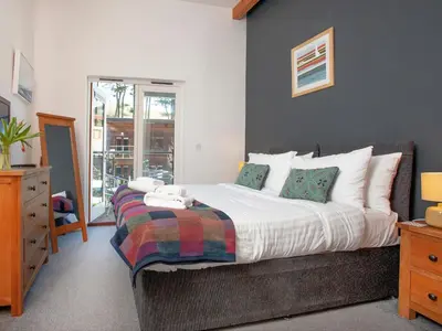 a bedroom with a large bed and a window at Trebisken - Cottage in Porthtowan