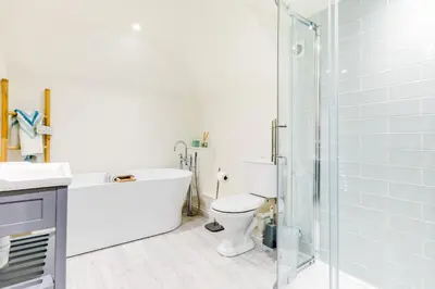 a bathroom with a tub and a toilet and a shower at Goose Cottage - within the Helland Barton Farm collection in Delabole