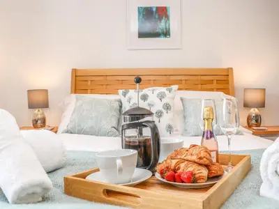 a tray with a coffee maker and croissants on a bed at Ty Bryn in Marazion