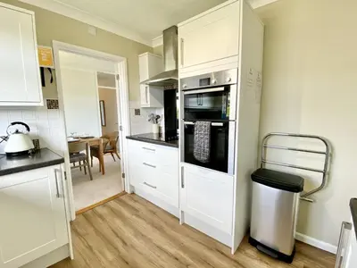 a kitchen with white cabinets and a stove top oven at Myebon in Padstow