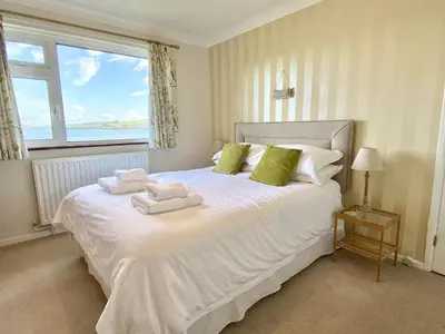 a bedroom with a white bed with towels on it at Myebon in Padstow