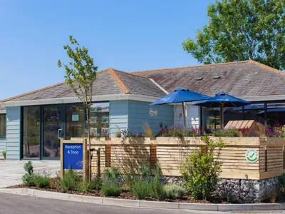 a restaurant with umbrellas in front of a building at Penmarlam Lodge Retreat 18 in Fowey