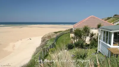 a house on the beach next to a sandy beach at B04 Beachcroft B4, Riviere Towans in Hayle