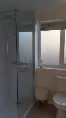 a bathroom with a glass shower and a toilet at The Picture House Stylish Apartment in Fowey in Fowey