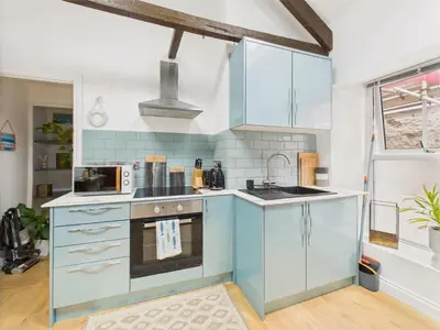 a kitchen with blue cabinets and a sink at Stylish Central Famouth Studio with Parking | WiFi | in Falmouth