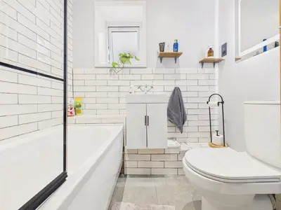 a white bathroom with a tub and a toilet at Stylish Central Famouth Studio with Parking | WiFi | in Falmouth