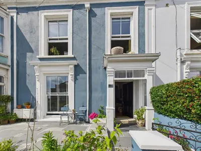 a blue house with white windows and plants at Stylish Central Famouth Studio with Parking | WiFi | in Falmouth
