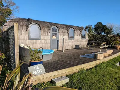 a yurt with a deck and a swimming pool at The Pasty - Lydcott Glamping in East Looe