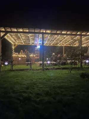 a group of people sitting under a pavilion at night at The Pasty - Lydcott Glamping in East Looe