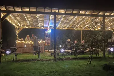 a group of people standing under a pavilion at night at The Pasty - Lydcott Glamping in East Looe