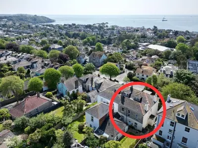 an aerial view of a house in a neighborhood at Manacles - Spacious flat near beach with sea views & parking in Falmouth