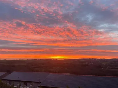 a sunset with the sun setting in the sky at Bimbling Cottage in Redruth
