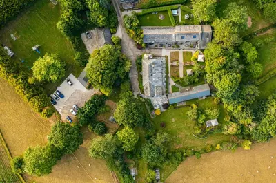 an overhead view of a mansion in the midst of trees at Linhay at East Trenean Farm -Luxury retreat for 2 with stunning rural views, private hot tub and EV charging in Looe