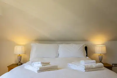 a bedroom with a bed with towels on it at Trewhiddle Retreat V27 by Together Travel - Luxury 3-Bedroom Villa in St Austell