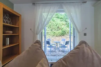 a bed in a room with a view of a window at Trewhiddle 41 by Together Travel - Stylish Coastal Countryside Retreat in St Austell