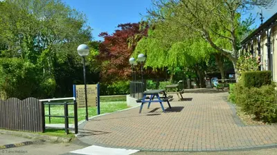 a picnic table on a brick sidewalk next to a building at 15 Tudor Court, Tolroy Manor in Hayle